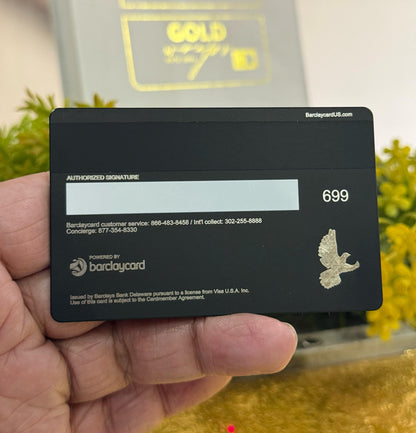 Black barclays metal card with text and a logo held by a hand, with a blurred background
