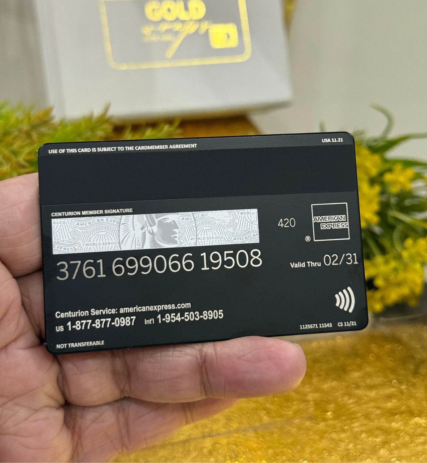 Black American Express card held in a hand with a blurred background