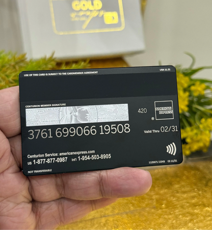 Black American Express card held in a hand with a blurred background
