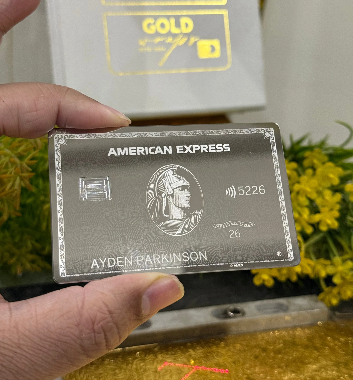 new Mirror platinum American Express card held by a hand with a blurred background