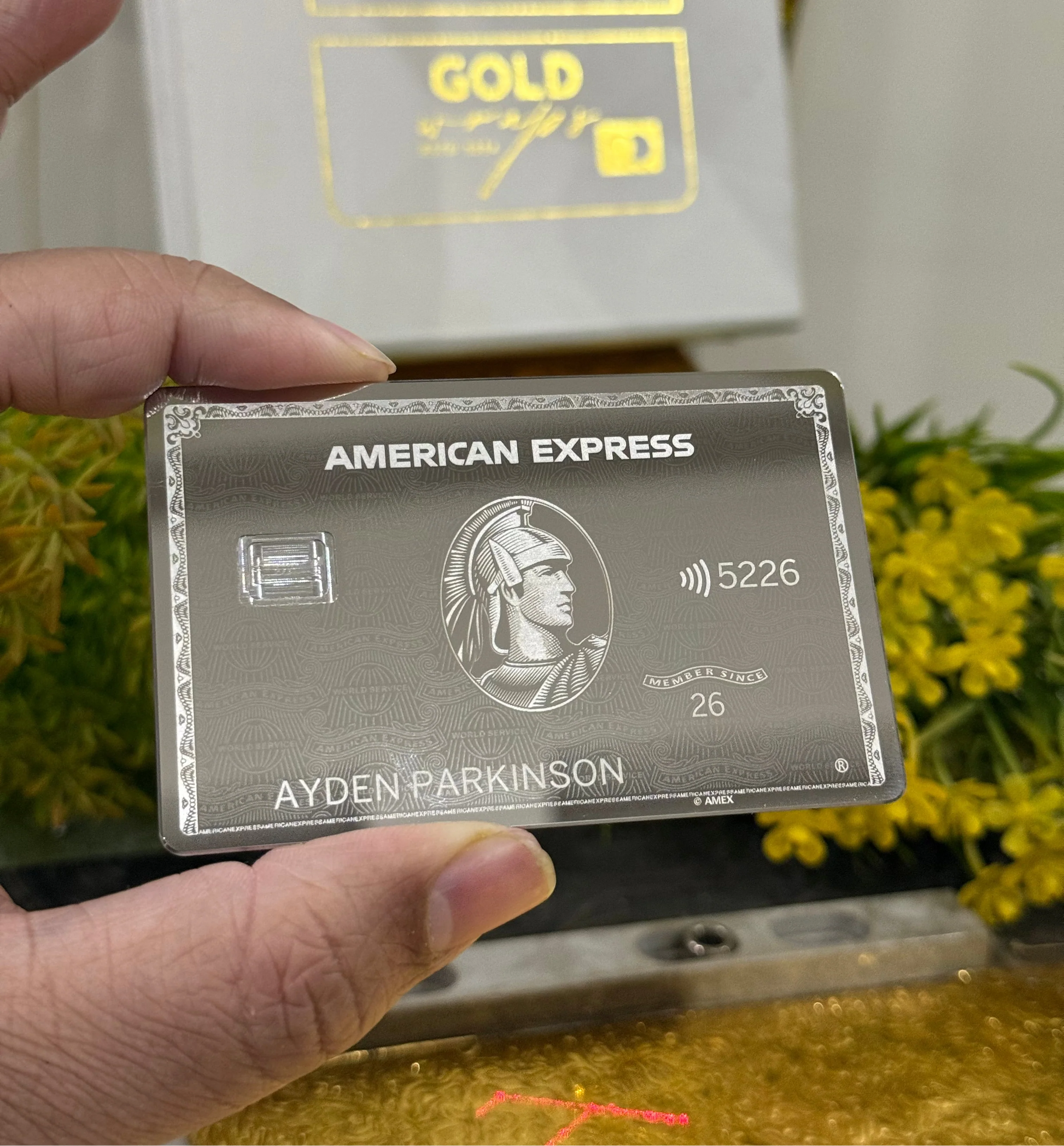 new Mirror platinum American Express card held by a hand with a blurred background