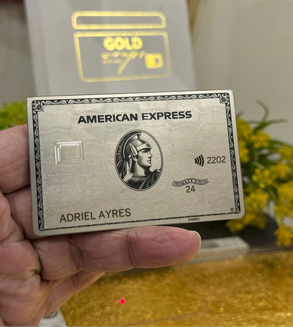 Platinum American Express card held by a hand with a blurred background