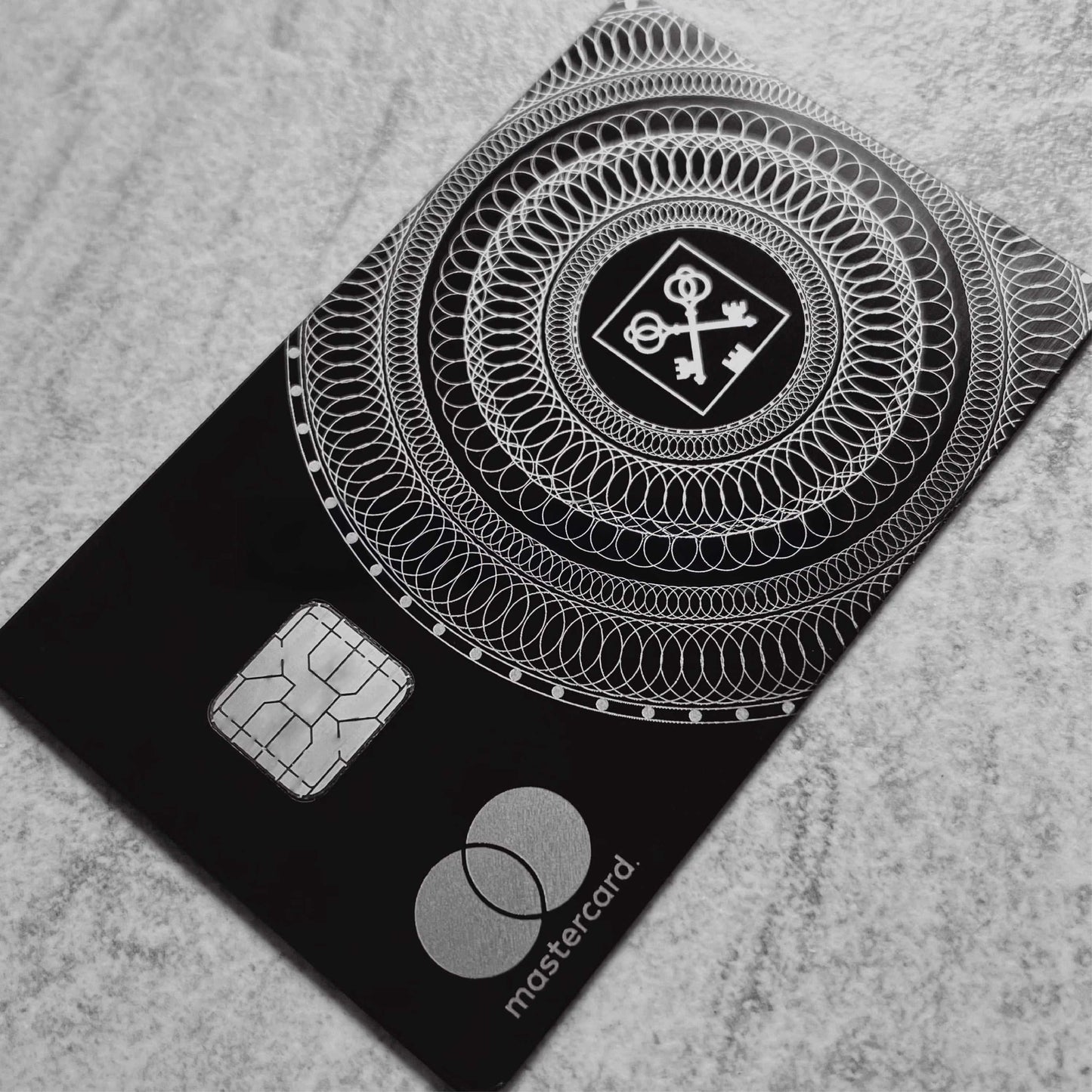 Elite Goldman Lampe black metal card with intricate engraved detailing for luxury branding